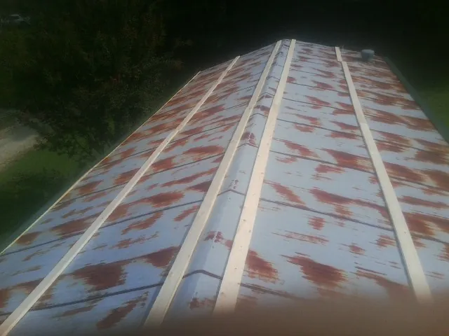 Rusted metal roof panels with new wood purlins before replacement — Storm Damage Roof Repair in Otis by Roofing Brothers